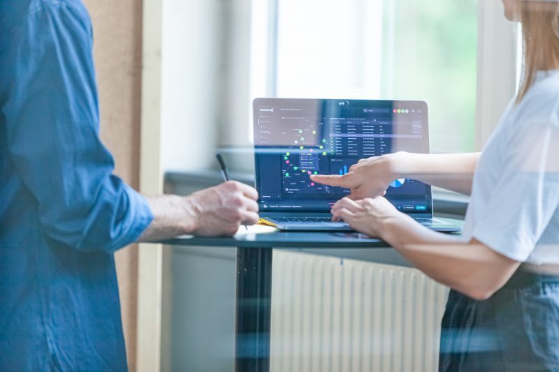 Two UX designers evaluating a design on a laptop.